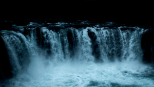 Water flows down at a large wide waterfall.